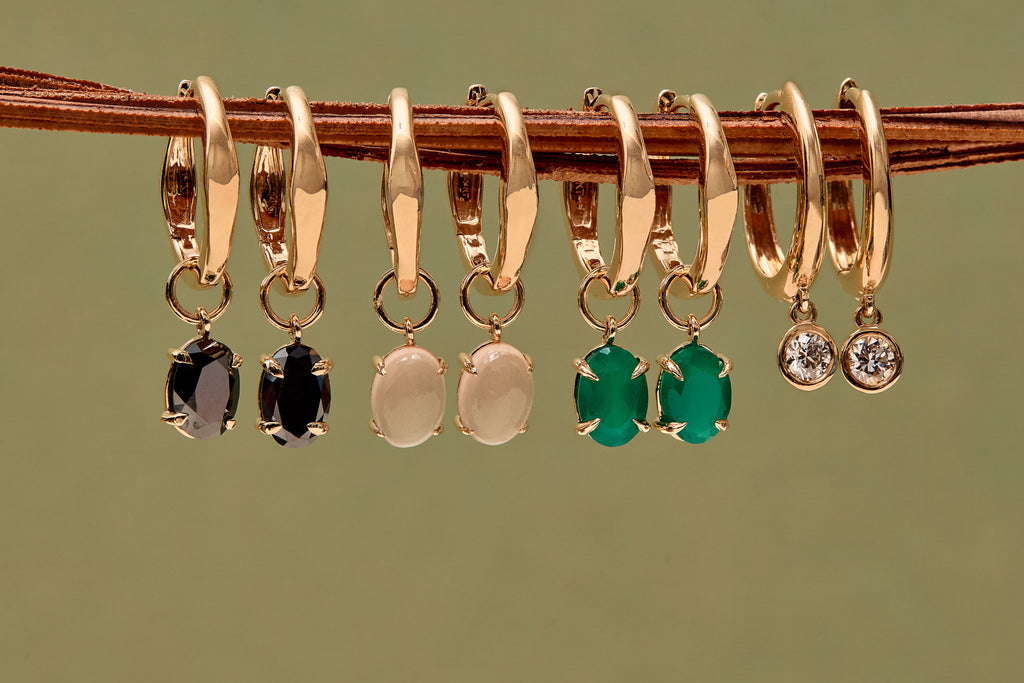 Aretes de aro huggie de oro de la colección ARA Collection. El set incluye dijes con ónix negro, cuarzo rosa, ágata verde y circonitas. Pendientes de aro minimalistas y elegantes de ARA Joyería.